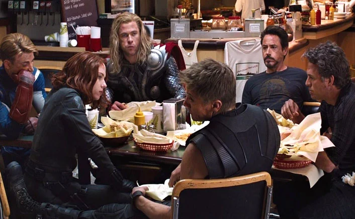 A group of superheros sitting around a table