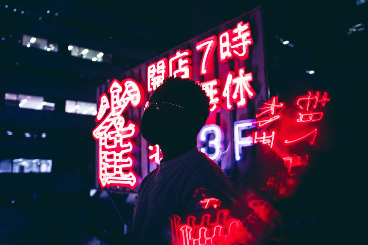 Man standing in front of red neons in Chinese